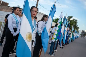 Grupo de personas con banderas durante el acto por los 90 años de Juan José Castelli.