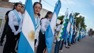 Grupo de personas con banderas durante el acto por los 90 años de Juan José Castelli.