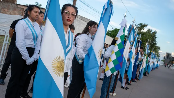 Grupo de personas con banderas durante el acto por los 90 años de Juan José Castelli.