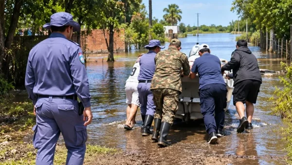 Personal policial y otros agentes avanzan por una calle anegada.
