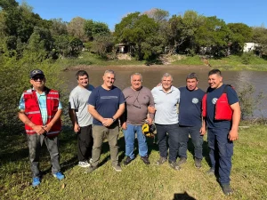 Bomberos y autoridades junto al río Negro durante la demostración del hidrodeslizador