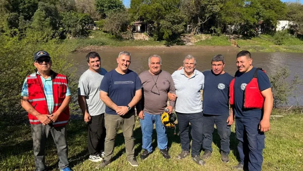 Bomberos y autoridades junto al río Negro durante la demostración del hidrodeslizador