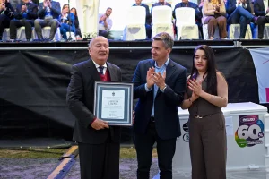 Juan de la Cruz Riquelme sostiene una placa junto a Leandro Zdero durante el aniversario de Laguna Limpia