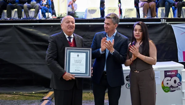 Juan de la Cruz Riquelme sostiene una placa junto a Leandro Zdero durante el aniversario de Laguna Limpia