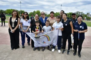 Estudiantes y adultos posan con un trofeo y una bandera durante el encuentro deportivo en Resistencia.