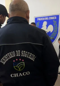 Agentes custodian al detenido frente al escudo de la Policía del Chaco