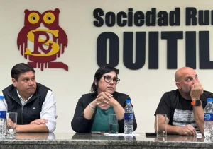 Tres representantes participan en una charla sobre financiamiento y empleo en Quitilipi, frente al logo de la Sociedad Rural.