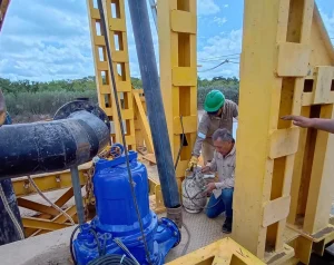 Personal técnico trabaja sobre una electrobomba en la toma del río Bermejo.