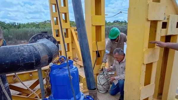 Personal técnico trabaja sobre una electrobomba en la toma del río Bermejo.