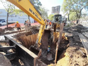 Maquinaria y operarios trabajan en una excavación para reparar una cañería de agua potable en Resistencia.