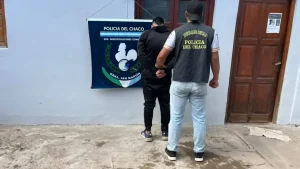 Un efectivo policial custodia a un joven frente a la División Investigaciones Complejas de General San Martín.