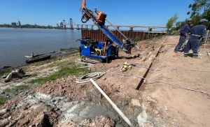 Maquinaria trabaja en la defensa costera de San Pedro Pescador con el puente General Belgrano de fondo